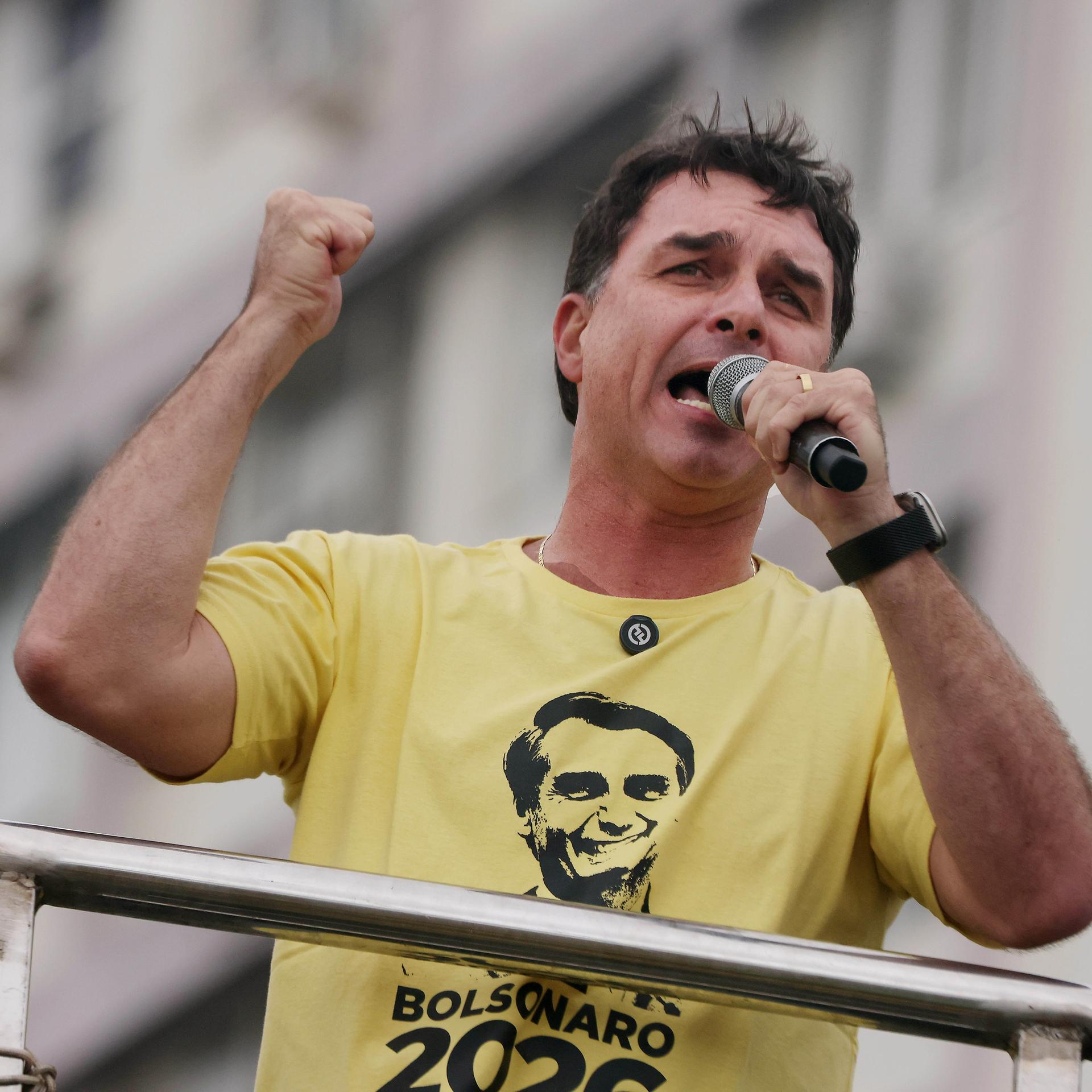 Senator Flavio Bolsonaro spricht energisch während einer Demonstration. Auf seinem T-Shirt ist das Gesicht seines Vaters. 
