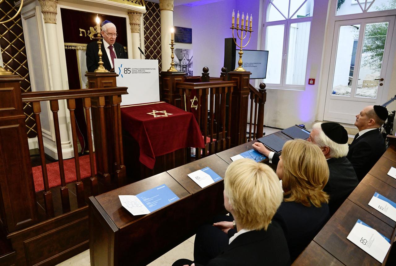 Der Präsident des Zentralrats der Juden, Schuster, spricht bei einer Gedenkveranstaltung in der Beth Zion Synagoge in Berlin. Vor ihm auf Bänken sitzen verschiedene Politiker.