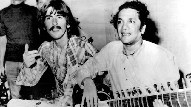 Hollywood: Beatles-Gitarrist George Harrison sitzt neben Ravi Shankar aus Indien, der Sitar spielt. Ravi Shankar war Harrisons Sitar-Lehrer.