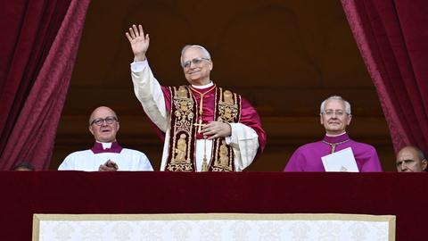 Der neu gewählte Papst, Leo XIV, steht auf dem Balkon des Petersdoms im Vatikan am 8. Mai 2025. Seine Hände sind gefaltet und er hat ein Lächeln auf den Lippen - Er scheint sichtlich glücklich über sein neues Amt. 
