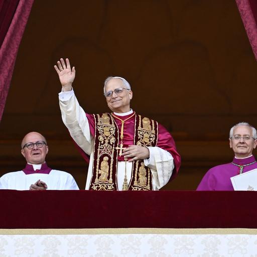 Der neu gewählte Papst, Leo XIV, steht auf dem Balkon des Petersdoms im Vatikan am 8. Mai 2025. Seine Hände sind gefaltet und er hat ein Lächeln auf den Lippen - Er scheint sichtlich glücklich über sein neues Amt. 
