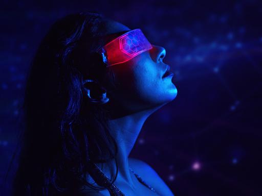 Eine Person trägt eine Neon-VR-Brille in einer futuristischen, blauen Cyberspace-Umgebung.

