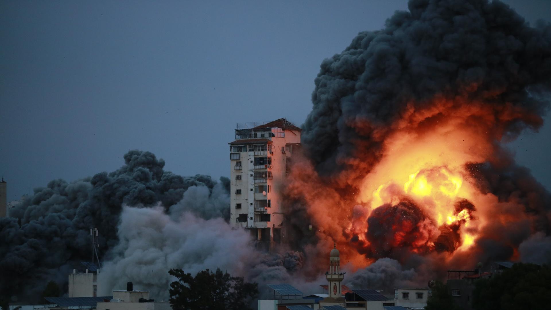 Ein Hochhaus in Gaza-Stadt nach einem Angriff der israelischen Streitkräfte. Eine riesige Säule aus Feuer und Rauch ist neben einem Hochhaus zu sehen Ein Hochhaus in Gaza-Stadt nach einem Angriff der israelischen Streitkräfte. Eine riesige Säule aus Feuer und Rauch ist neben einem Hochhaus zu sehen