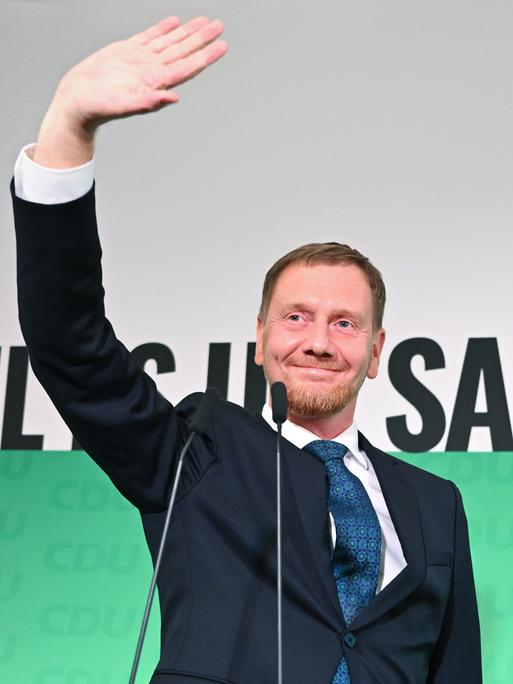 Michael Kretschmer (CDU), amtierender Ministerpräsident von Sachsen und Spitzenkandidat bei der Landtagswahl am 1. September 2024, winkt nach der Verkündung der ersten Hochrechnungen der Landtagswahlen auf der Bühne.