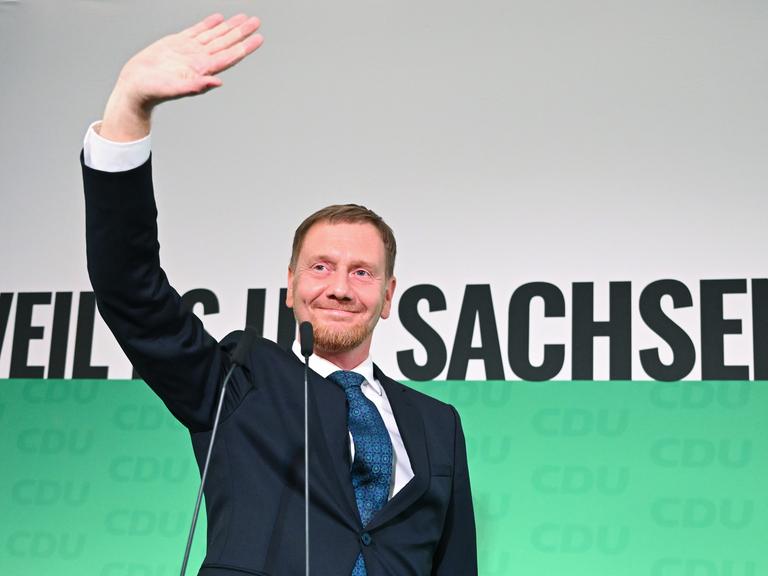 Michael Kretschmer (CDU), amtierender Ministerpräsident von Sachsen und Spitzenkandidat bei der Landtagswahl am 1. September 2024, winkt nach der Verkündung der ersten Hochrechnungen der Landtagswahlen auf der Bühne.