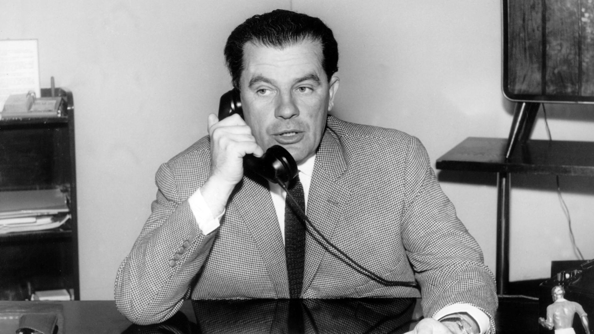 Der Sportreporter Herbert Zimmermann, Leiter der Abteilung Sport beim Norddeutschen Rundfunk, telefoniert an seinem Schreibtisch im Funkhaus (undatierte Aufnahme).