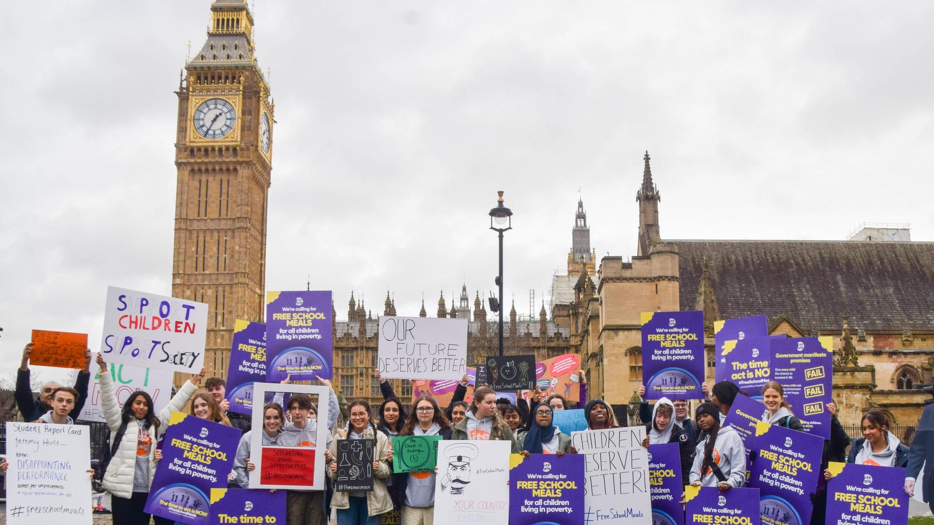 Großbritannien, London: Schüler demonstrieren mit Plakaten für kostenloses Schulessen.