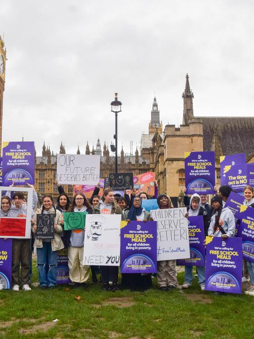 Großbritannien, London: Schüler demonstrieren mit Plakaten für kostenloses Schulessen.