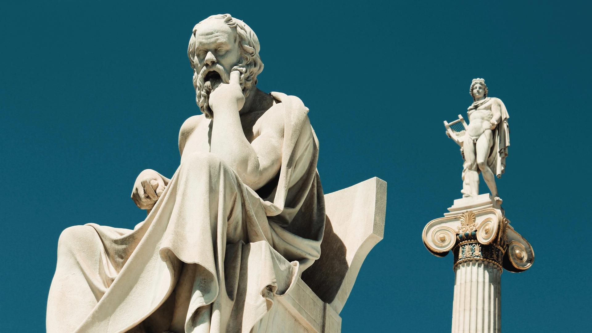 Statue des Sokrates vor blauem Himmel