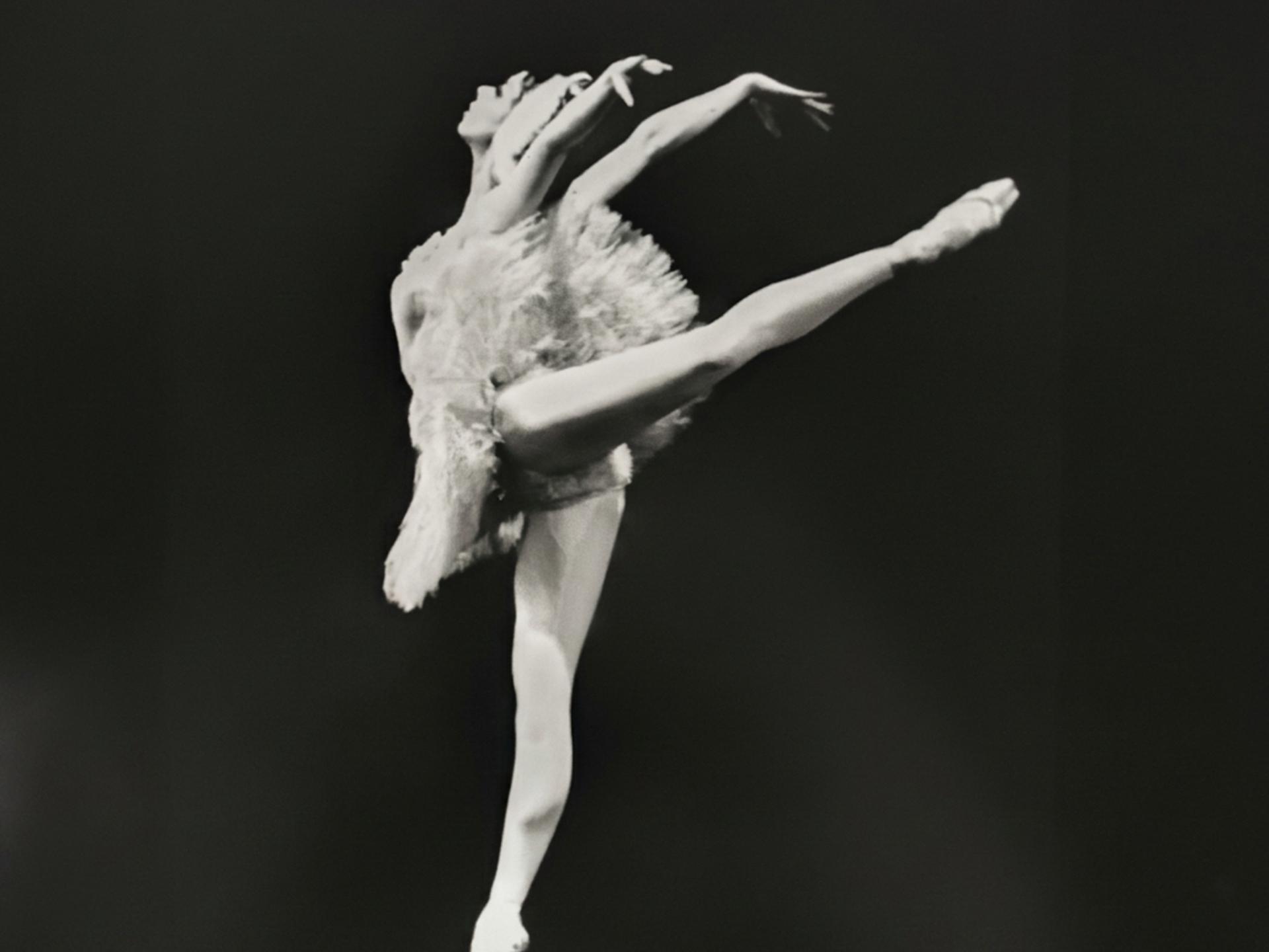 Schwarzweißfoto einer Ballerina im weißen Tanzkleid auf der Bühne. Schwarzweißfoto einer Ballerina im weißen Tanzkleid auf der Bühne.