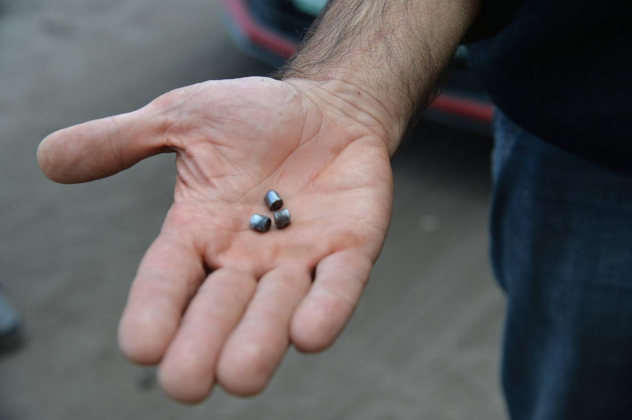 Ein Mann zeigt Teile einer Streubombe, die in der ukrainischen Stadt Kupjansk im Oblast Charkiw eingesetzt wurde.