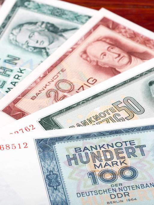 DDR-Geldscheine liegen auf einem Tisch, wie ein Fächer ausgebreitet. 