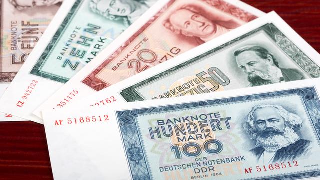 DDR-Geldscheine liegen auf einem Tisch, wie ein Fächer ausgebreitet. 