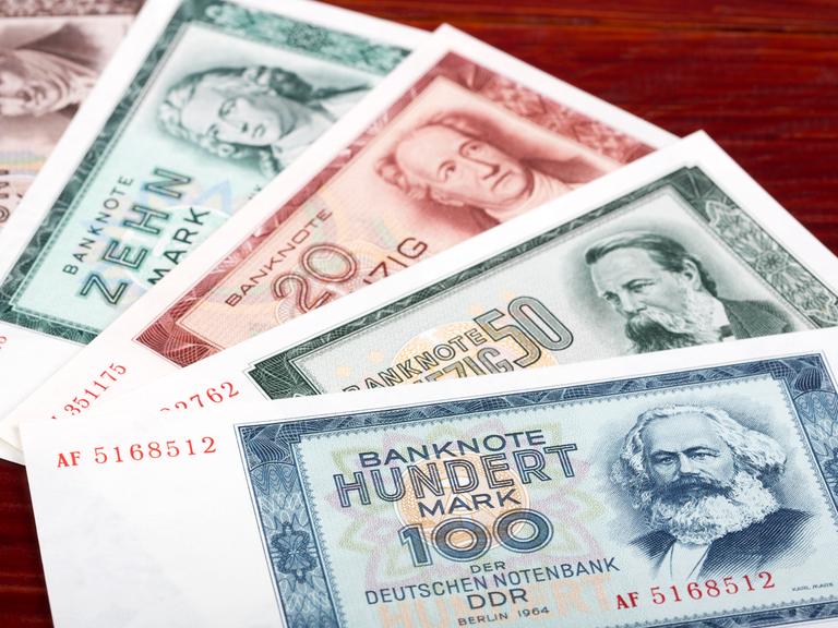 DDR-Geldscheine liegen auf einem Tisch, wie ein Fächer ausgebreitet. 