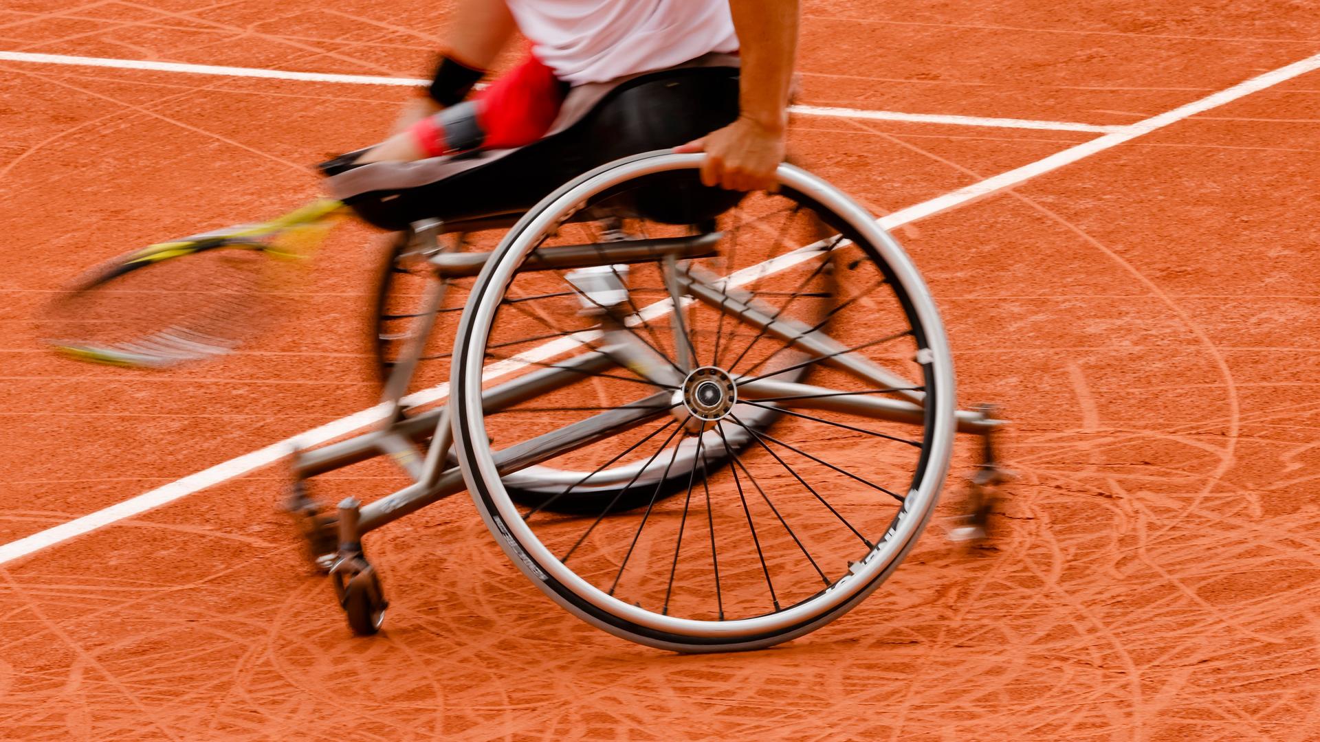 Ein Tennisspieler im Rollstuhl fährt über den Platz.
