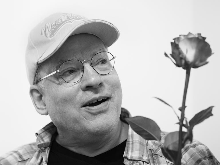 Der Filmemacher, Autor, Künstler und Schwulenaktivist Rosa von Praunheim hält eine Rose in der Hand. Der Filmemacher, Autor, Künstler und Schwulenaktivist Rosa von Praunheim hält eine Rose in der Hand.