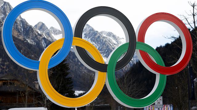 Die olympischen Ringe stehen vor den norditalienischen Bergen 