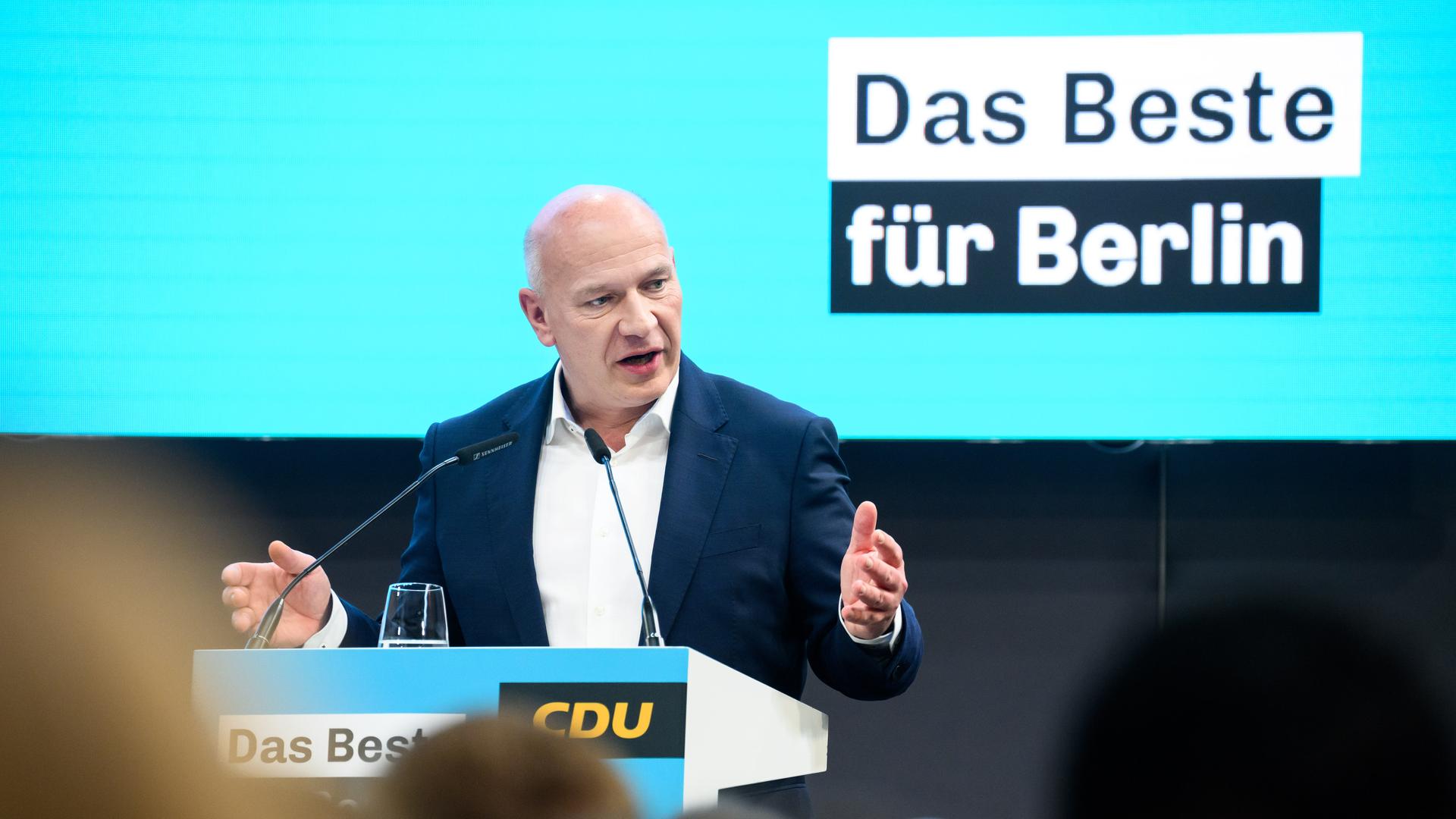 Kai Wegner steht an einem Redepult vor einem türkisfarbenen Hintergrund. Zu lesen ist der Slogan "Das Beste für Berlin".
