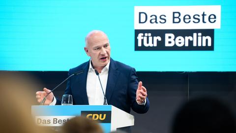 Kai Wegner steht an einem Redepult vor einem türkisfarbenen Hintergrund. Zu lesen ist der Slogan "Das Beste für Berlin".