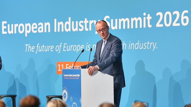 Das Bild zeigt Bundeskanzler Friedrich Merz, der auf einem Wirtschaftsgipfel eine Rede hält. 