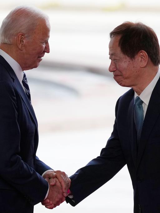 US-Präsident Joe Biden (l.) und Mark Liu, CEO von TSMC, geben sich auf einer Bühne die Hand.