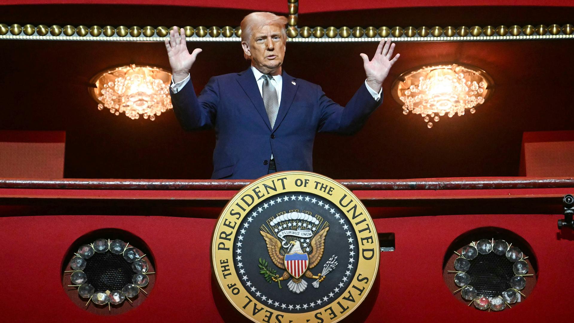 US-Präsident Donald Trump steht mit erhobenen Armen zwischen zwei Kronleuchtern in einer Loge des Kennedy Center in Washington, an der Brüstung ist ein rundes Schild mit dem Präsidentenwappen angebracht: Seal of the President of the United States. US-Präsident Donald Trump steht mit erhobenen Armen zwischen zwei Kronleuchtern in einer Loge des Kennedy Center in Washington, an der Brüstung ist ein rundes Schild mit dem Präsidentenwappen angebracht: Seal of the President of the United States.