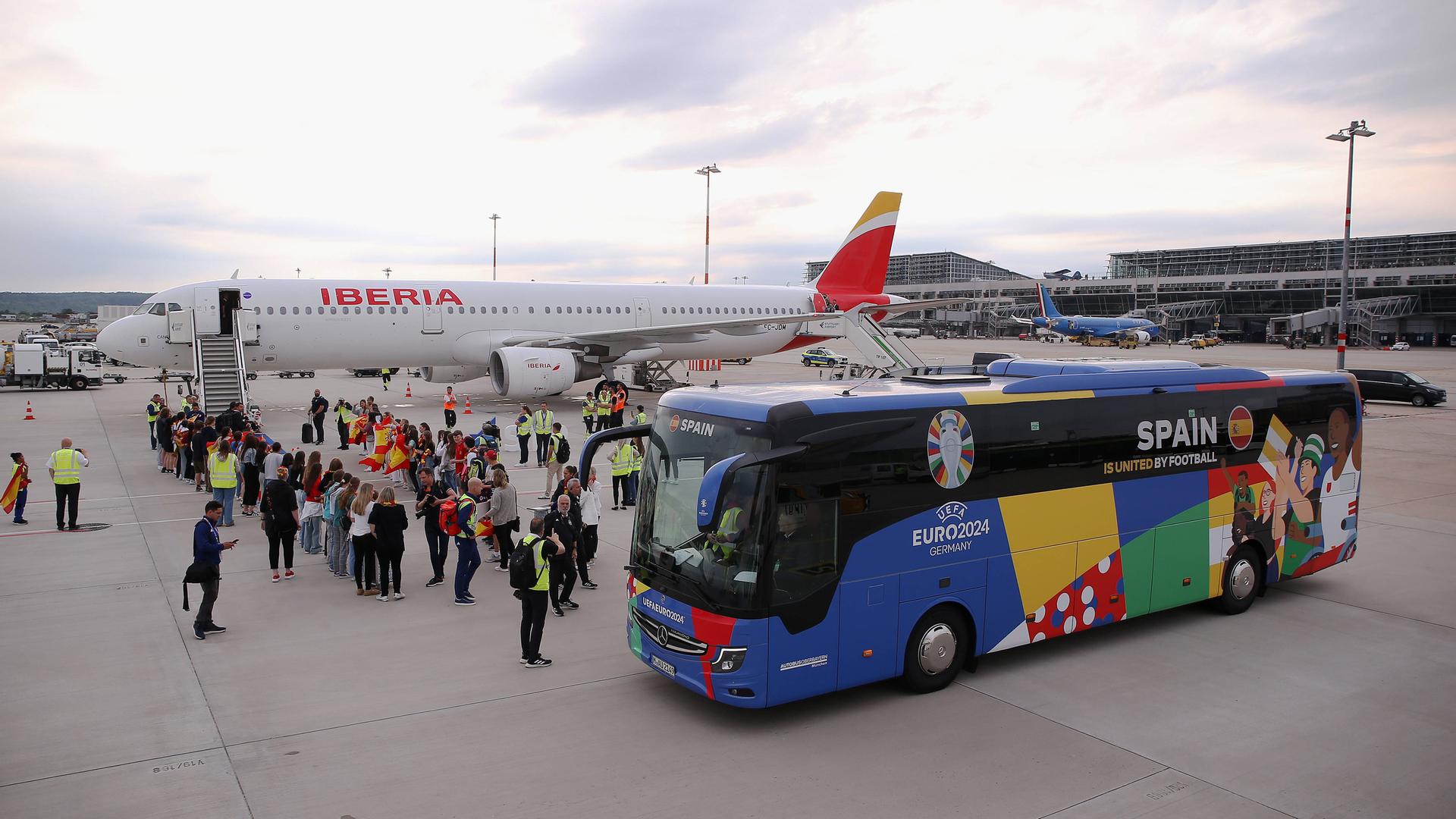 Auf dem Foto ist zu sehen, wie die spanische Fußballmannschaft am Stuttgarter Flughafen ankommt und von Personal empfangen wird.