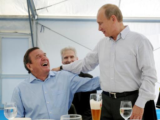 Der damalige Vorstandsvorsitzende der Nord Stream AG, Bundeskanzler a. D. Gerhard Schröder und der russische Ministerpräsident Wladimir Putin (v.l.n.r.) treffen sich an der Portovaya-Kompressorstation in Vyborg bei Bier und bester Laune.