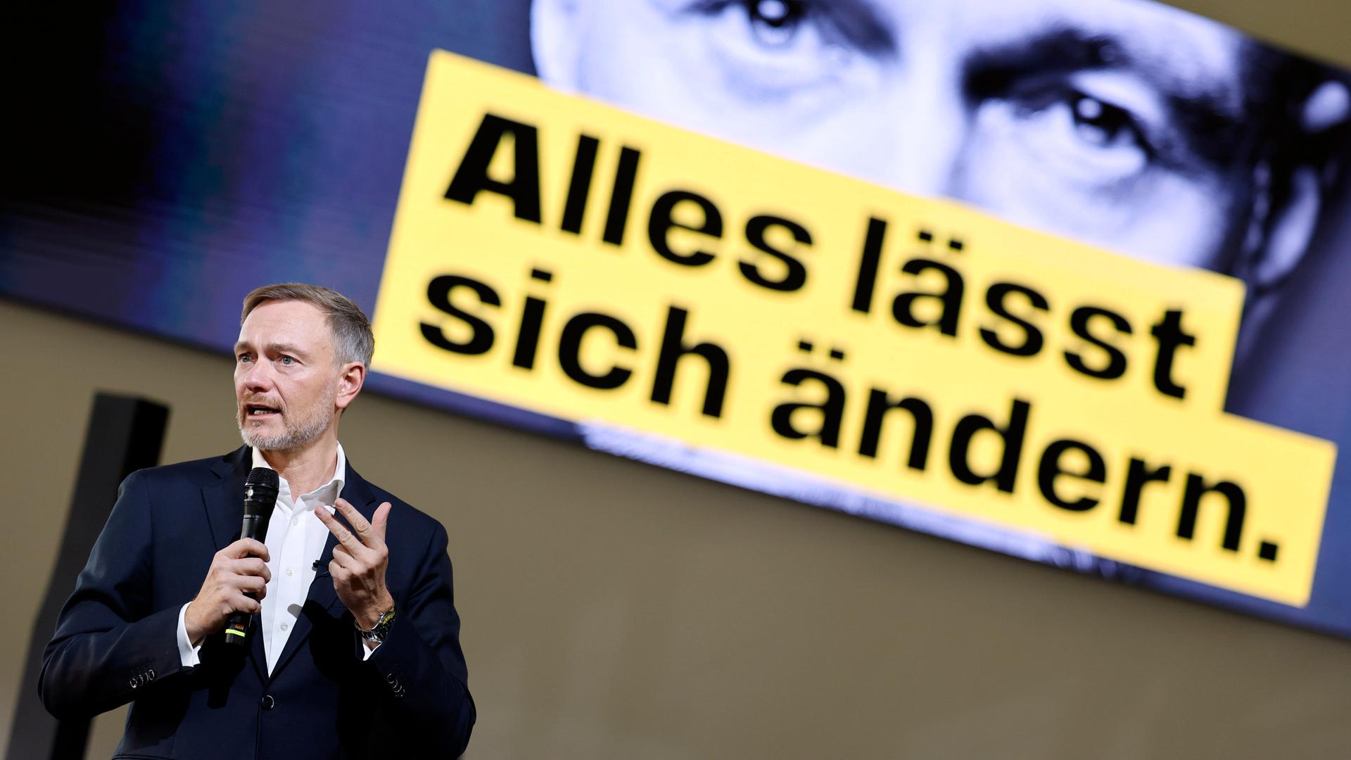 FDP-Spitzenkandidat Christian Lindner steht bei einer Wahlkampfveranstaltung der FDP im Confex an der Koelnmesse auf der Bühne und spricht in ein Mikrofon. Im Hintergrund ist auf einem Bildschirm ein Wahlplakat mit Lindners Gesicht zu erkennen.