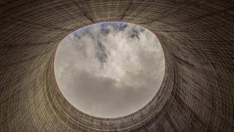 Blick aus einem Kühlturm für ein Kernkraftwerk, welches nicht fertig gestellt wurde. Oben zeigt sich der Himmel im kreisrunden Ausschnitt.
