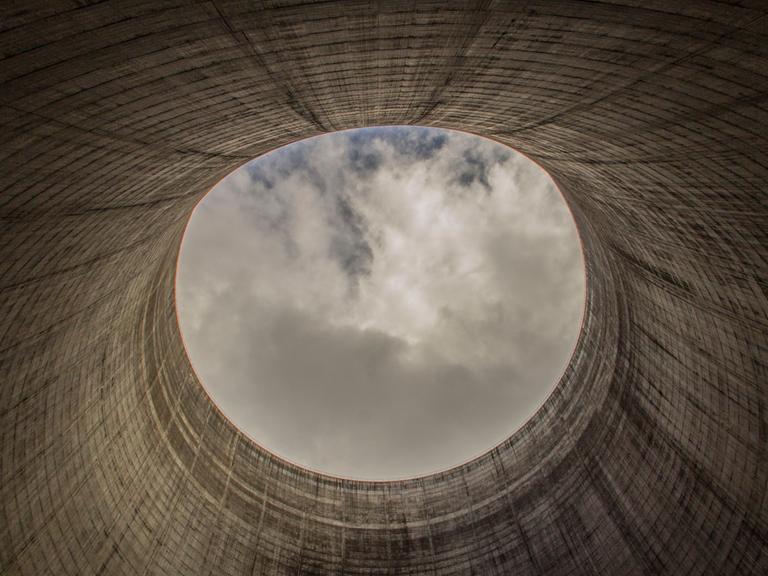 Blick aus einem Kühlturm für ein Kernkraftwerk, welches nicht fertig gestellt wurde. Oben zeigt sich der Himmel im kreisrunden Ausschnitt.