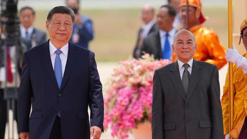 Der chinesische Staatschef Xi Jinging, links, und der kambodschanische König Norodom Sihamoni, rechts, nehmen an einer Begrüßungszeremonie am internationalen Flughafen von Phnom Penh teil. 
