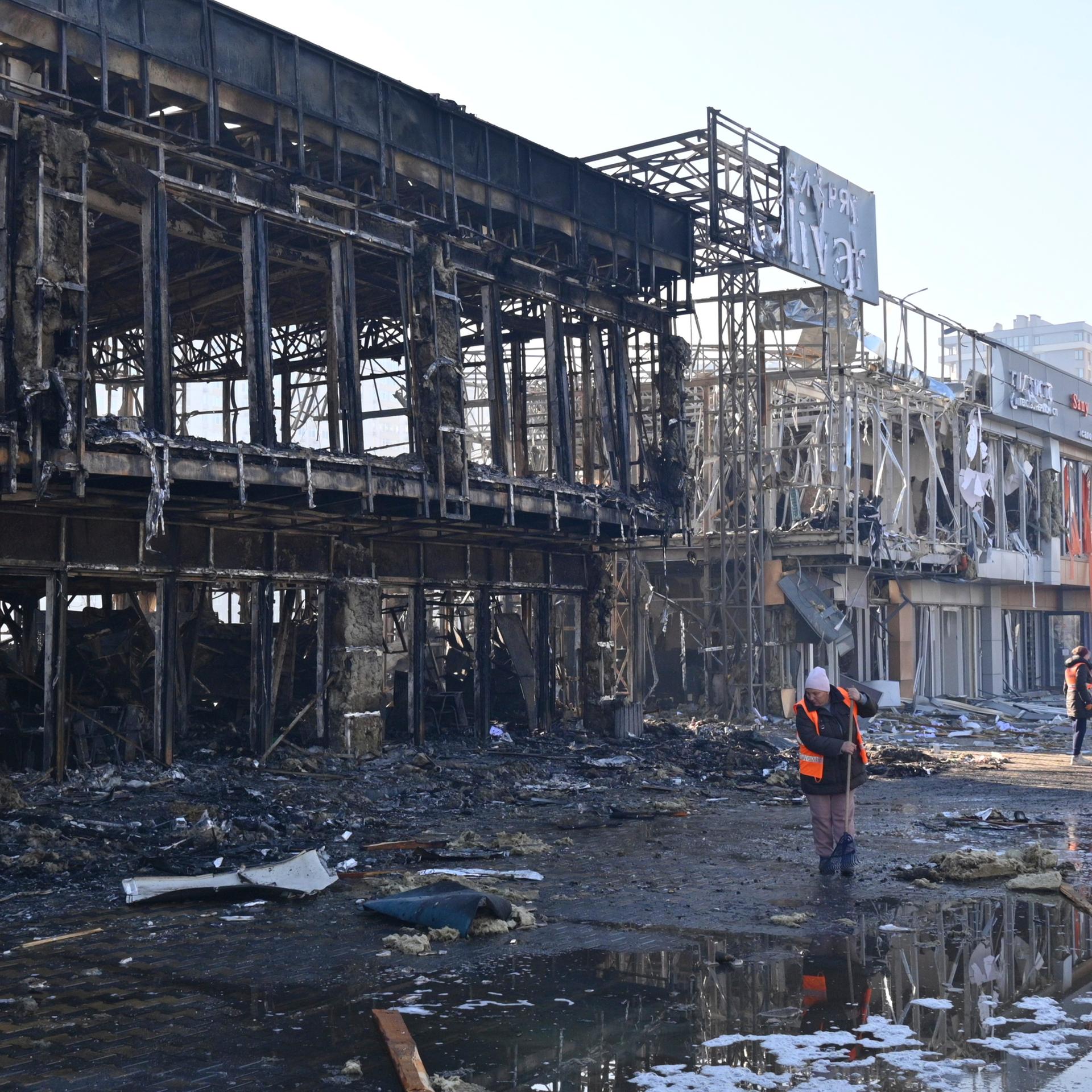 Odessa: Städtische Arbeiter räumen auf, nachdem russische Drohnen während des nächtlichen Angriffs Geschäfte getroffen haben. 