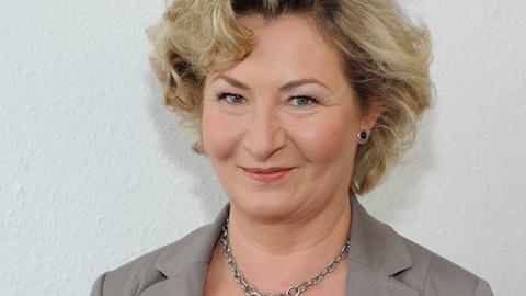Ada Borkenhagen lächelt in die Kamera. Sie hat kurze blonde Locken und trägt einen grauen Blazer.