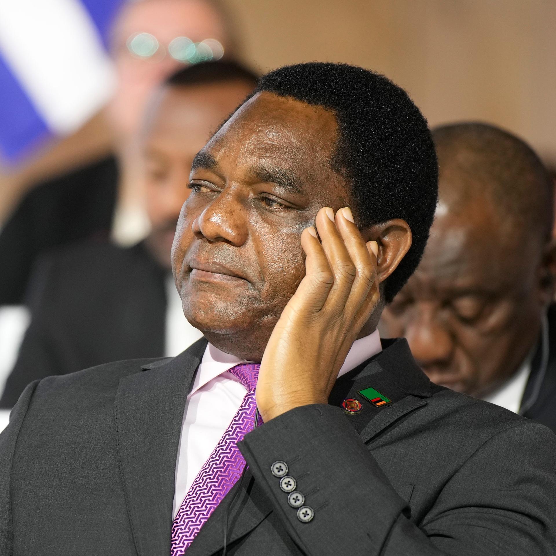 Der sambische Präsident Hakainde Hichilema hört in einer Konferenz zu. 