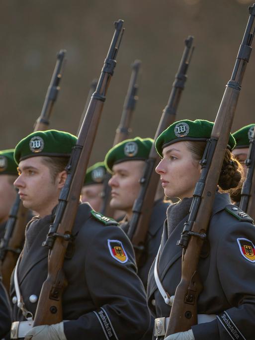 Soldatinnen und Soldaten des Wachbataillons der Bundeswehr treten an zu einem Empfang im Bendlerblock in Berlin. Sie tragen Uniformen und Waffen.