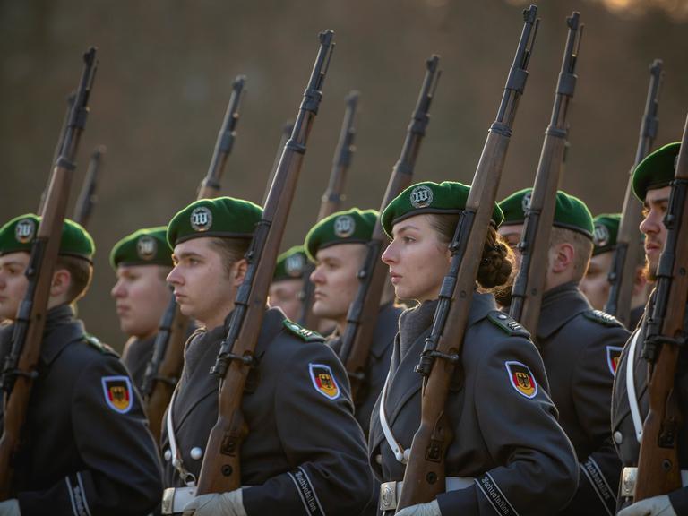 Soldatinnen und Soldaten des Wachbataillons der Bundeswehr treten an zu einem Empfang im Bendlerblock in Berlin. Sie tragen Uniformen und Waffen.