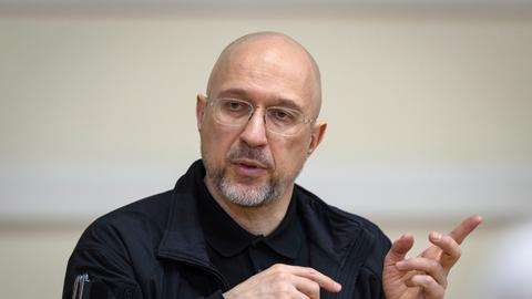 Der ukrainische Ministerpräsident Denys Schmyhal spricht während einer Pressekonferenz und gestikuliert mit beiden Händen. 