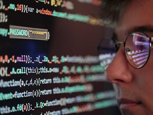 Ein Mann sitzt vor einem Rechner, auf dem Bildschirm sind Zahlencodes zu sehen.
Ein Mann sitzt vor einem Rechner, auf dem Bildschirm sind Zahlencodes zu sehen.