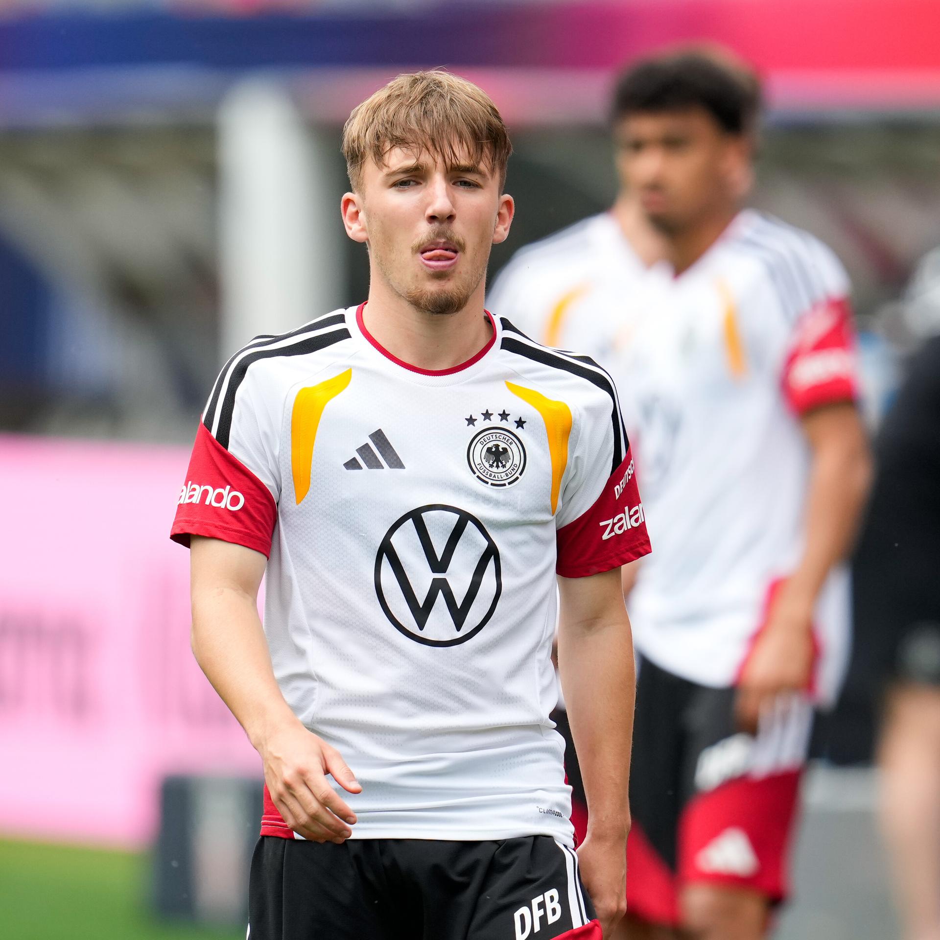 Karl trägt ein Trainingstrikot der deutschen Nationalmannschaft.