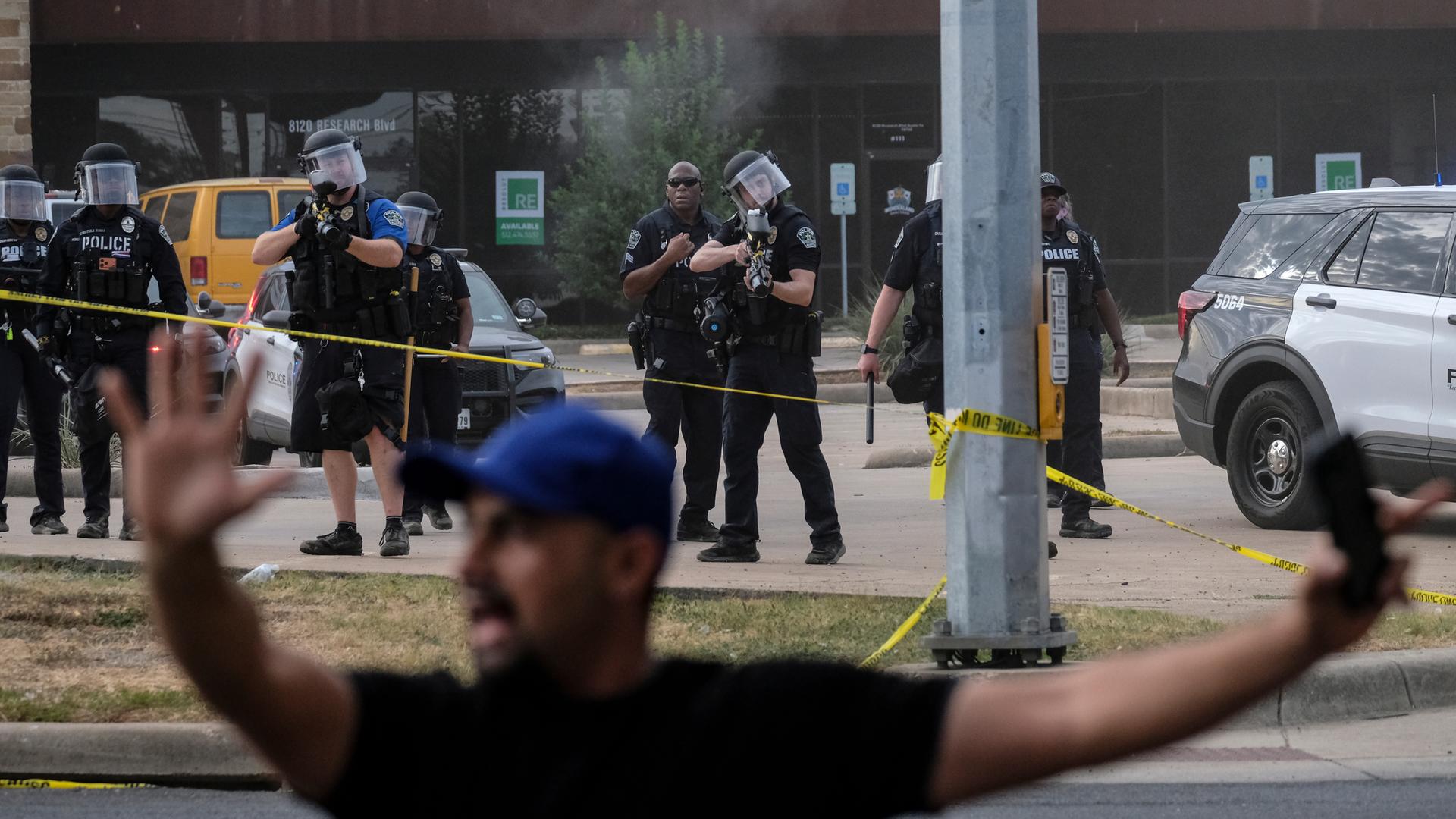 Einsatz von Agenten der Einwanderungs- und Zollbehörde ICE im texanischen Austin. Im Bildvordergrund steht ein Mann mit erhobenen Armen.