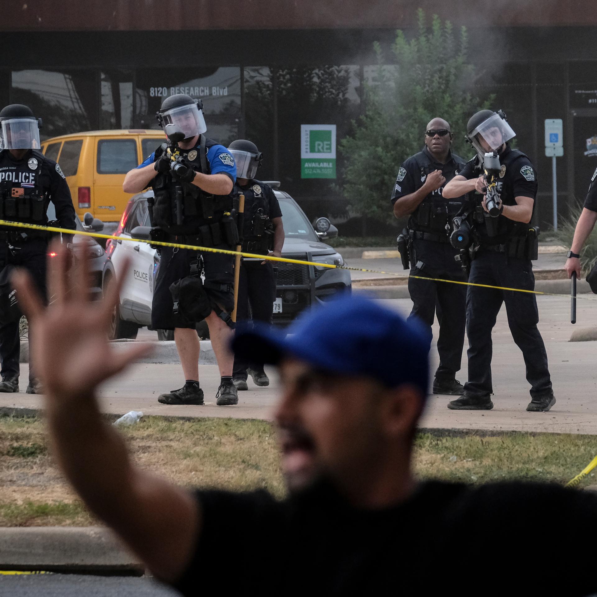 Einsatz von Agenten der Einwanderungs- und Zollbehörde ICE im texanischen Austin. Im Bildvordergrund steht ein Mann mit erhobenen Armen.