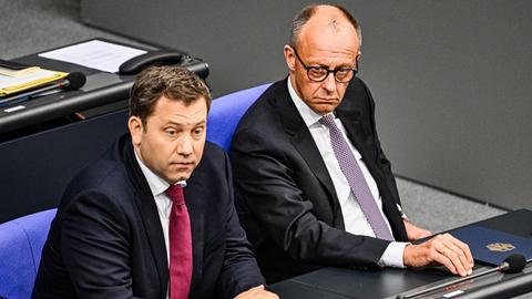 Bundeskanzler Friedrich Merz (r, CDU) und Vizekanzler Lars Klingbeil (SPD) sitzen nebeneinander auf der Regierungsbank im Deutschen Bundestag.