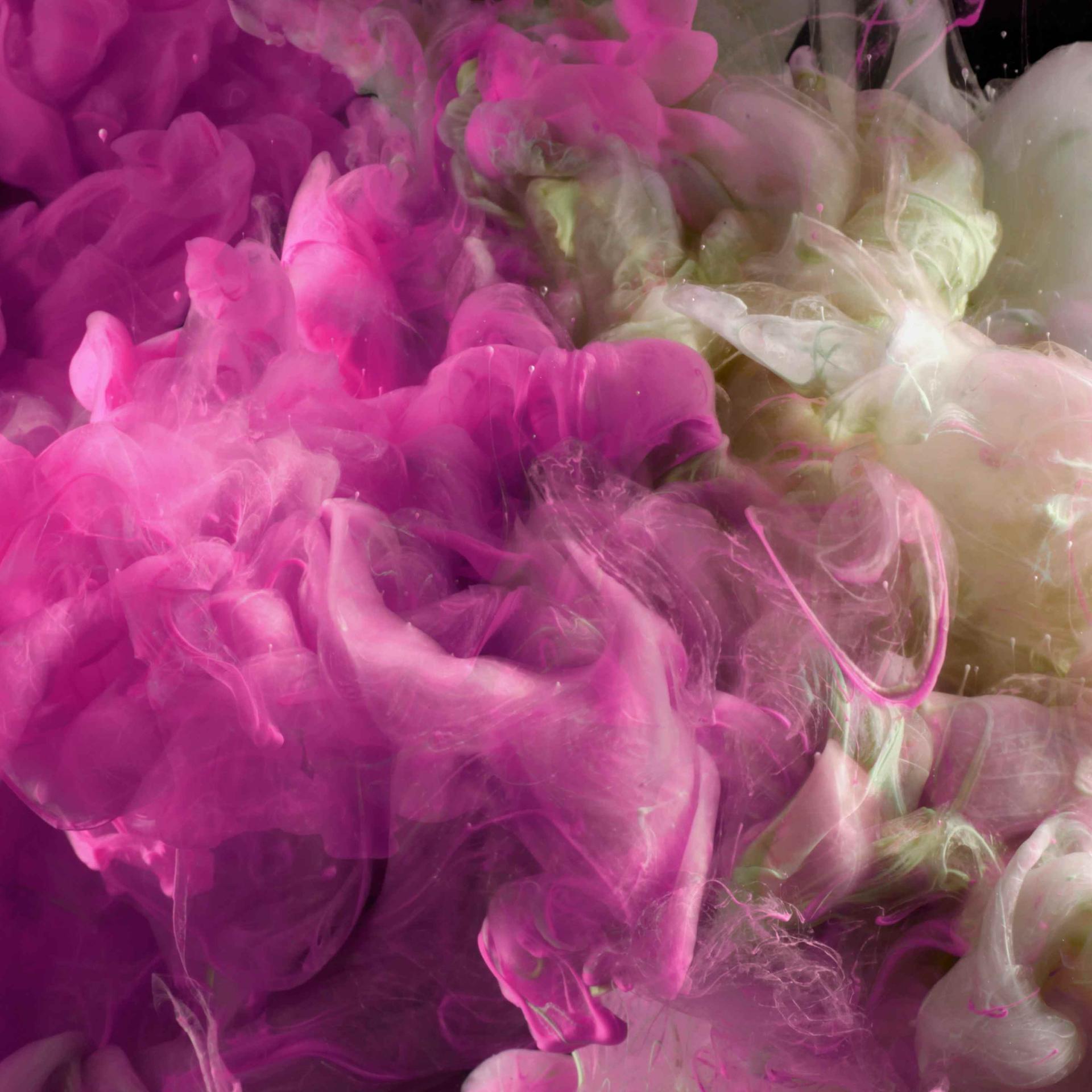 Abstrakter pink- und cremefarbener Rauch. Tintenfarben breiten sich in Wasser aus und bilden rauchartige Kleckse.