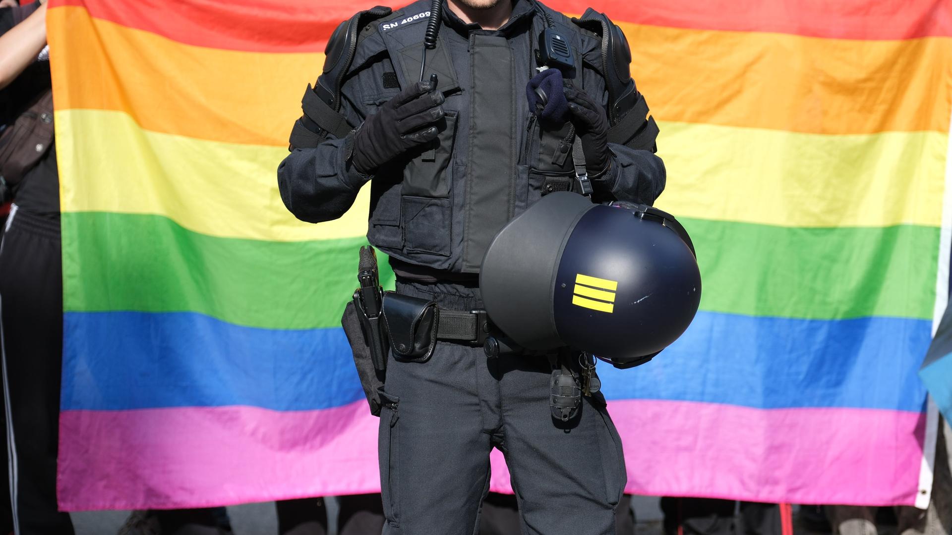 Ein Polizist steht vor einer Regenbogenfahne während eines Umzuges zum Christopher-Street-Day (CSD) in Bautzen