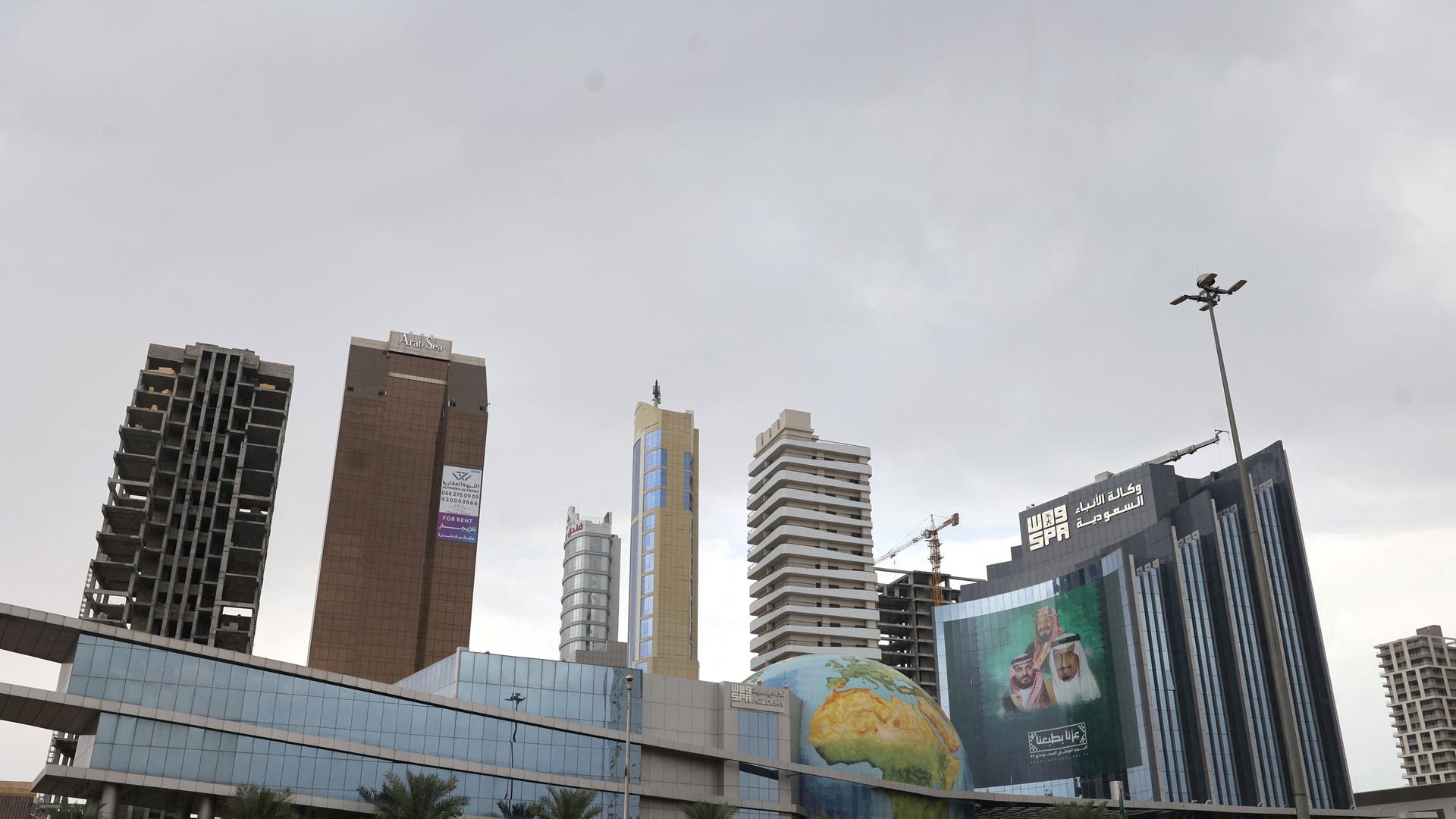 Vier hohe Gebäude stehen an einer Straße. Der Himmel ist bewölkt. Vier hohe Gebäude stehen an einer Straße. Der Himmel ist bewölkt.
