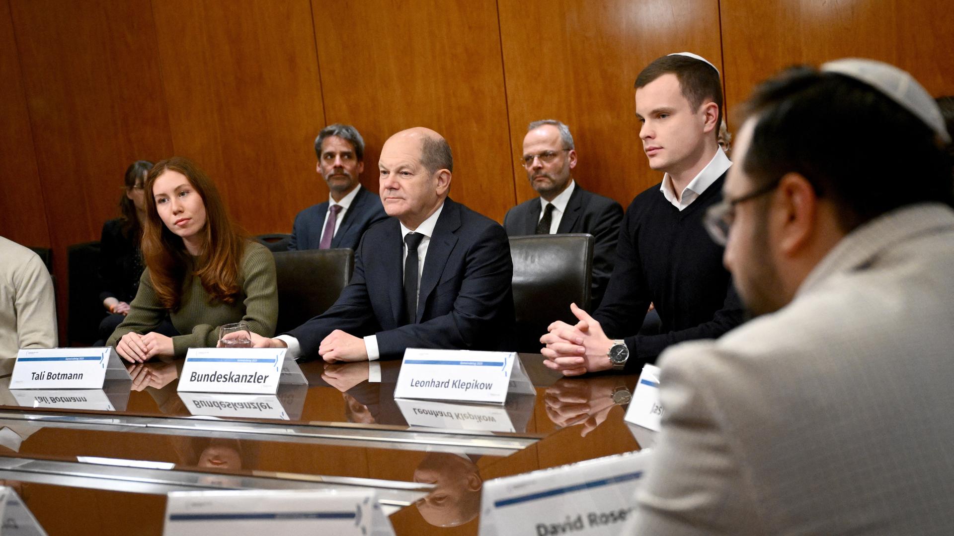 Olaf Scholz sitzt zwischen mehreren Gemeindetag-Teilnehmenden an einem Tisch.