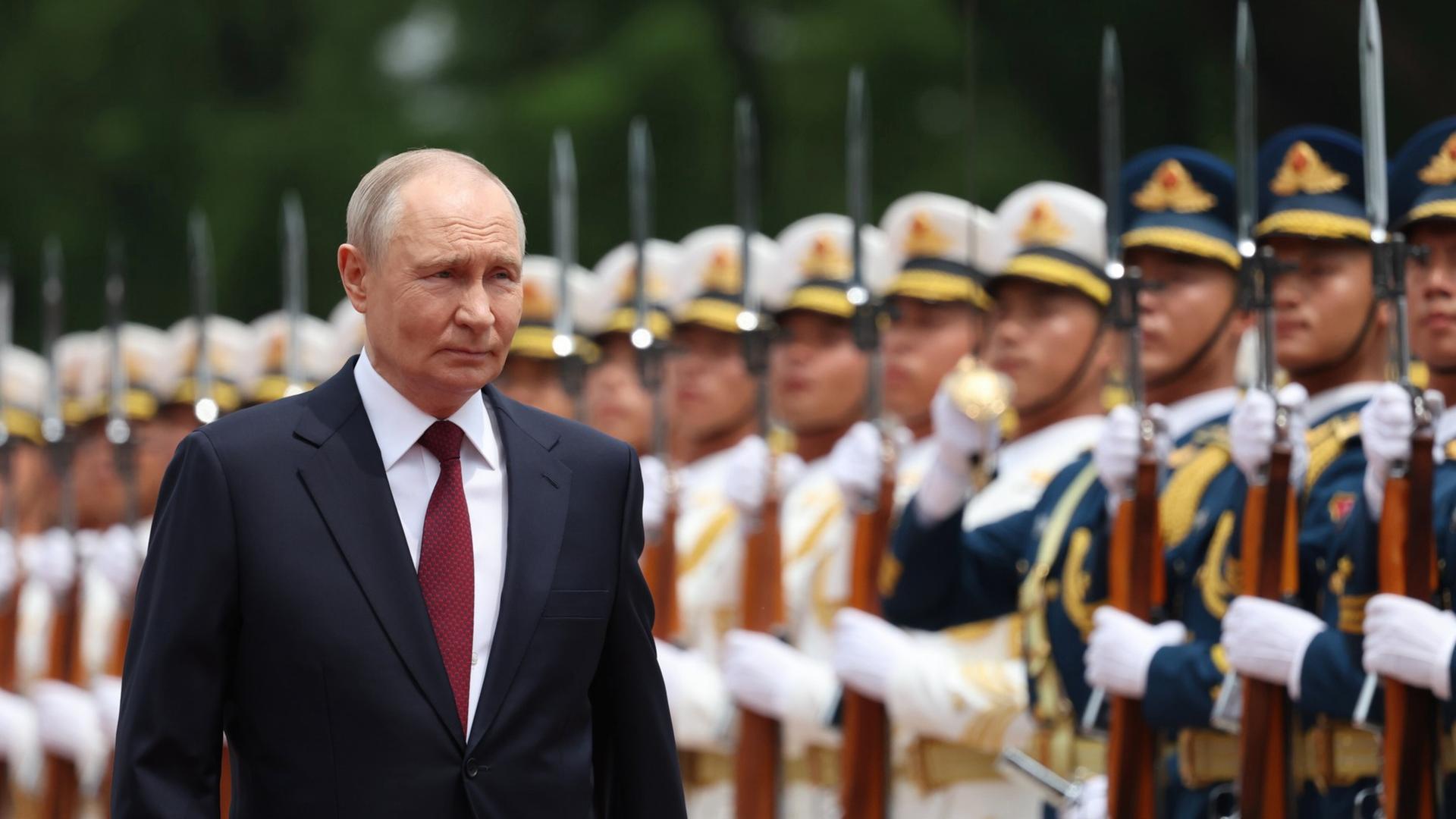 Wladimir Putin bei seinem jüngsten China-Besuch im Mai 2026. Er lächelt, im Hintergrund sind aufgereiht chinesische Soldaten zu sehen. Wladimir Putin bei seinem jüngsten China-Besuch im Mai 2026. Er lächelt, im Hintergrund sind aufgereiht chinesische Soldaten zu sehen.