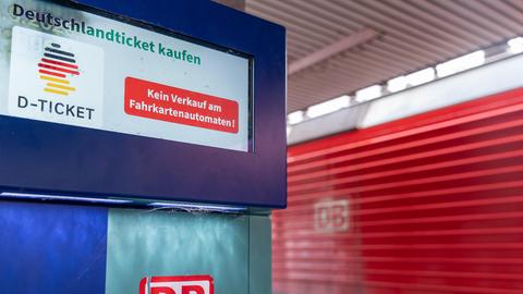 Ein Fahrkartenautomat der Deutschen Bahn mit Hinweis, dass das Deutschlandticket (D-Ticket) nicht am Automaten erhältlich ist. Im Hintergrund ist eine rote Lokomotive mit DB-Logo zu sehen.