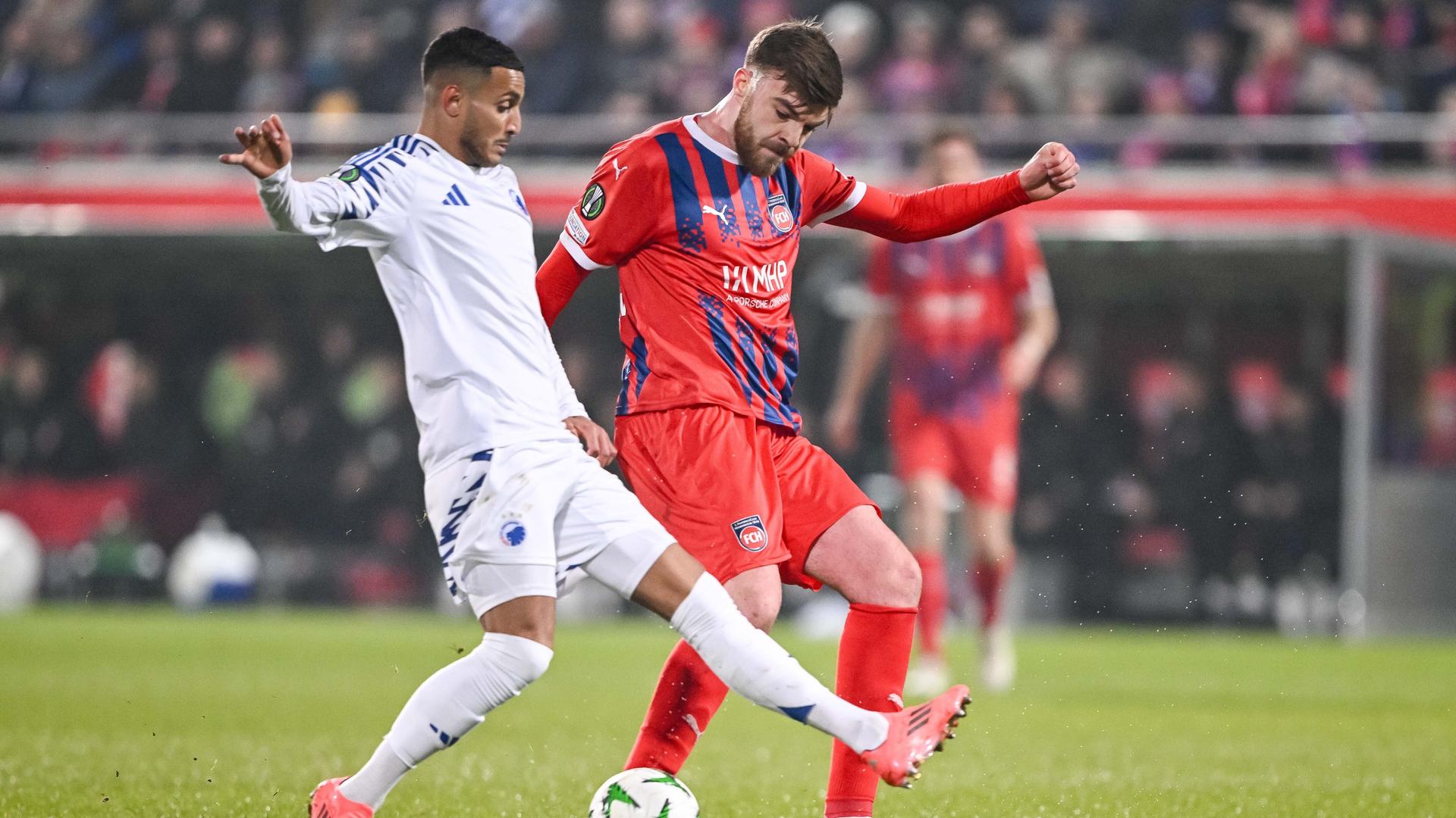 Das Bild zeigt eine Spielszene aus der Begegnung des 1. FC Heidenheim gegen FC Kopenhagen in der UEFA Conference League. Kopenhagens Elias Achouri ist im Duell gegen Heidenheims Julian Niehues.